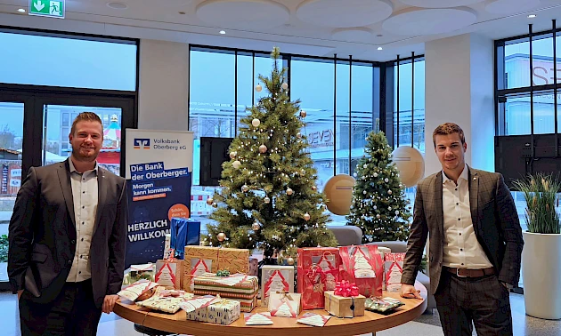 Fotos: Volksbank Oberberg --- Forum-Geschäftsstellenleiter Justin Wagner (links) und Max Klink von der Bausparkasse Schwäbisch Hall mit den Geschenken.