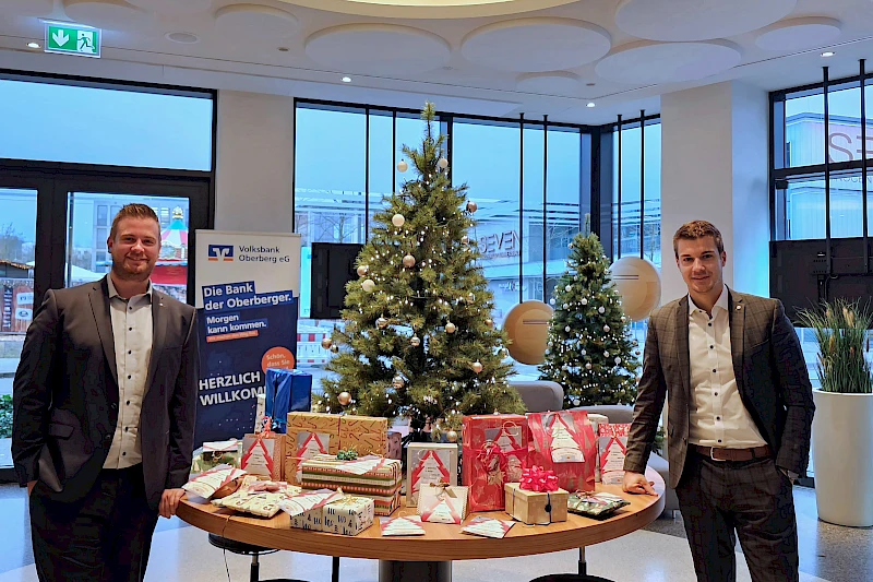 Fotos: Volksbank Oberberg --- Forum-Geschäftsstellenleiter Justin Wagner (links) und Max Klink von der Bausparkasse Schwäbisch Hall mit den Geschenken.