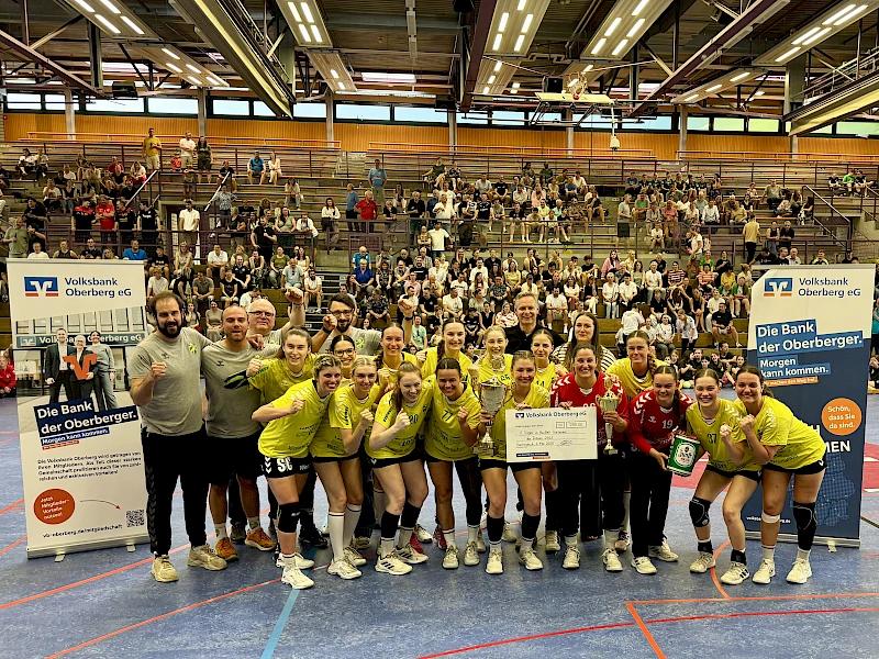 Jubelnde Handballerinnen der HC Gelpe/Strombach mit Pokal und Siegerscheck.