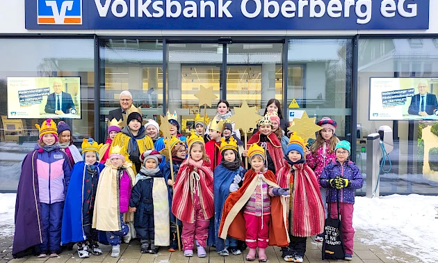 Sternsinger in Gewändern stehen am Eingang der Wiehler Hauptgeschäftsstelle der Volksbank Oberberg.