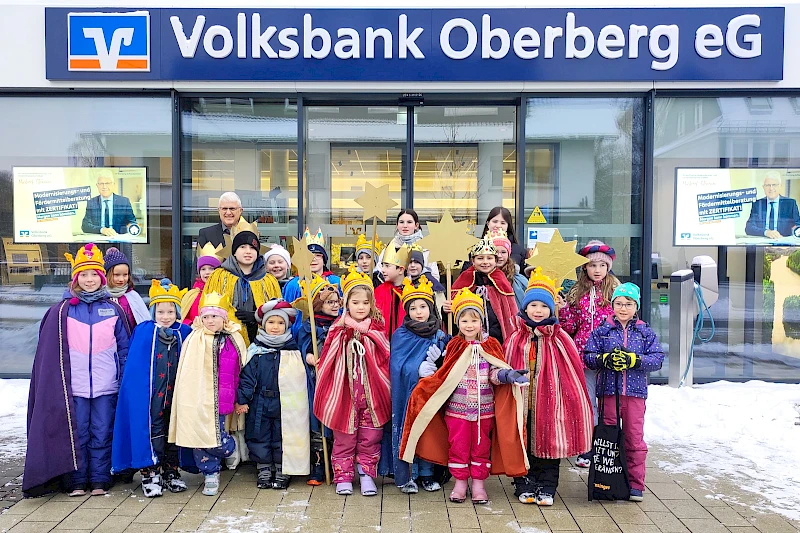 Sternsinger in Gewändern stehen am Eingang der Wiehler Hauptgeschäftsstelle der Volksbank Oberberg.