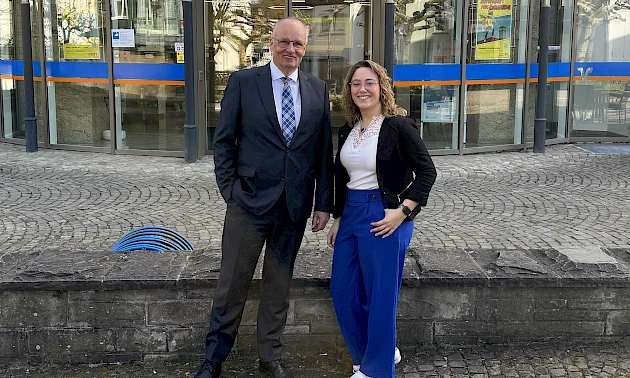 Niederlassungsleiter Stefan Weise und Geschäftsstellenleiterin Pia Wippenbeck stehen nebeneinander vor der Geschäftsstelle Engelskirchen und lächeln.