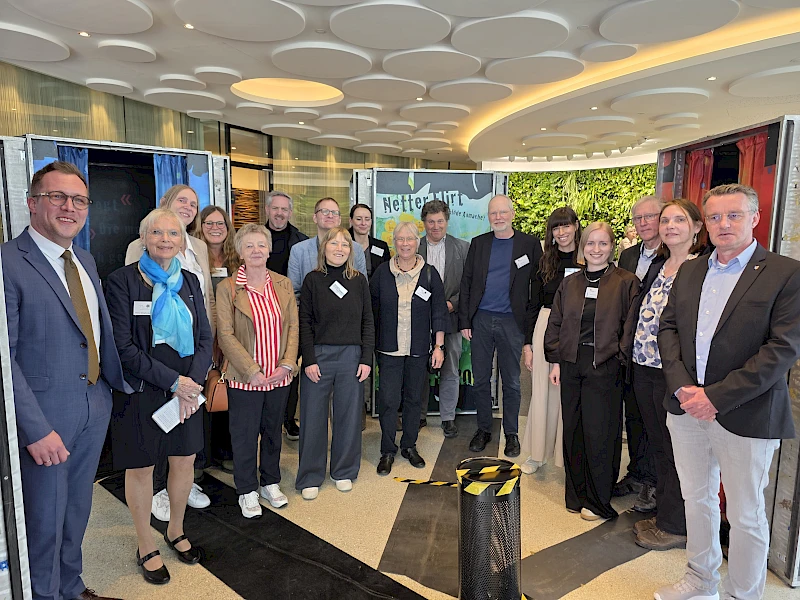 Mehrere Vertreterinnen und Vertreter von Beratungsstellen, Politik und Volksbank Oberberg stehen im Foyer der Volksbank Oberberg und eröffnen die Ausstellung „Echt krass!“ zum Thema Prävention sexualisierter Gewalt.