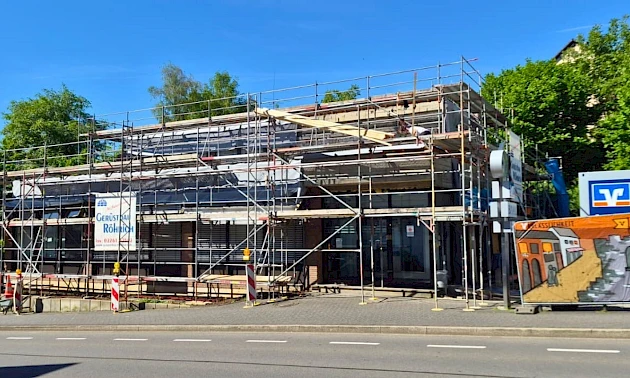 Die Geschäftsstelle der Volksbank Oberberg in Bergneustadt während der laufenden Kernsanierung. Das Gebäude ist vollständig von einem Gerüst umgeben.