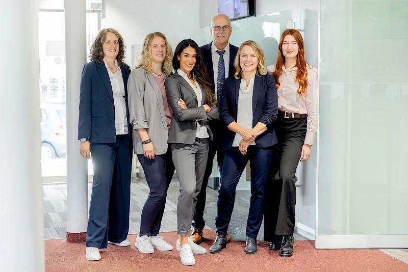Gruppenaufnahme von sechs Mitarbeitenden der Volksbank in den R&auml;umlichkeiten der Gesch&auml;ftsstelle Bielstein anl&auml;sslich des 125-j&auml;hrigen Jubil&auml;ums des Standorts.